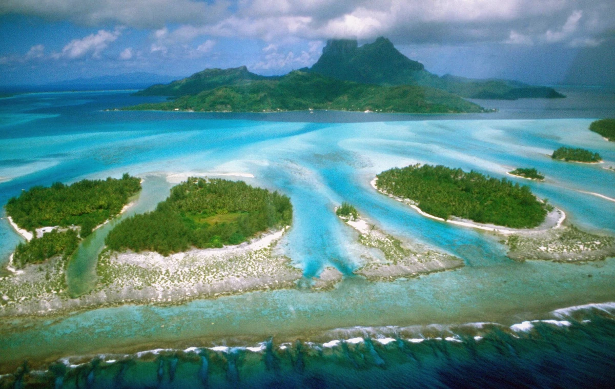 Mount Otemanu rising over the turquoise Bora Bora lagoon with a shallow sandbar in the foreground, French Polynesia