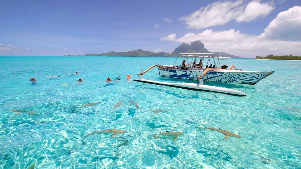 Motorized outrigger boat anchored in the turquoise Bora Bora lagoon on the Lagoon Service snorkeling tour, French Polynesia